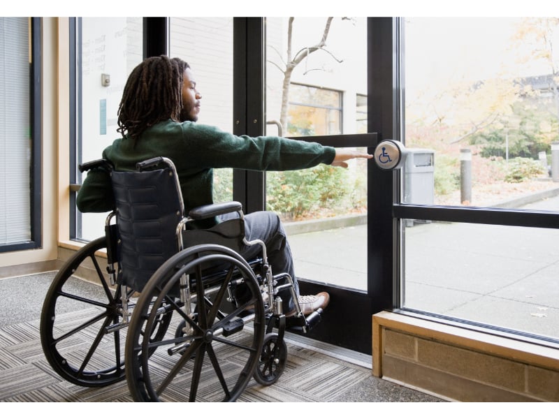 Adult in a wheelchair uses the automatic wheelchair door exit