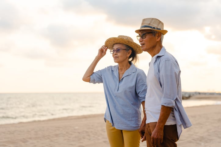 Older adult couple stands at the beach